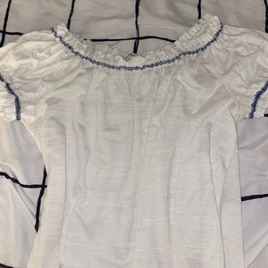 White shirt with puff shoulders and blue around neckline/sleeves
